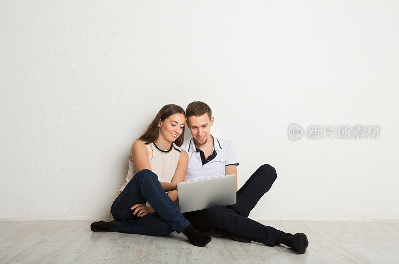 愉快的夫妇在家里使用笔记本电脑，拷贝空间