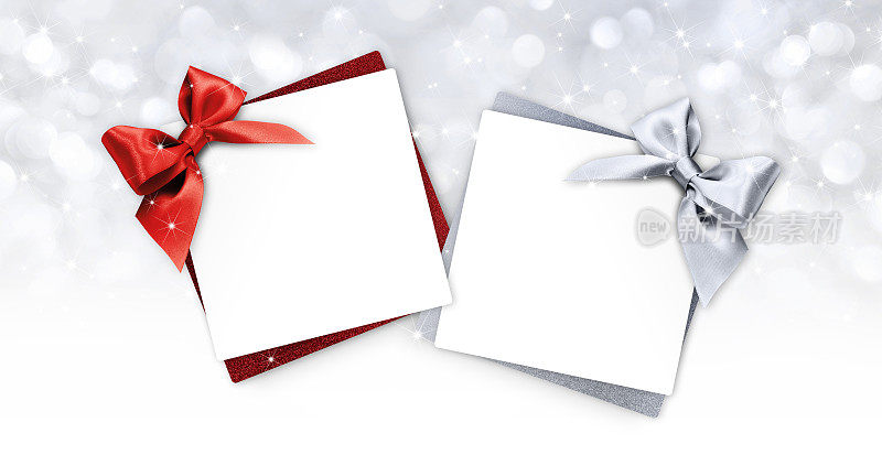 礼品卡与红色和银色丝带蝴蝶结孤立在圣诞明亮的灯光背景
