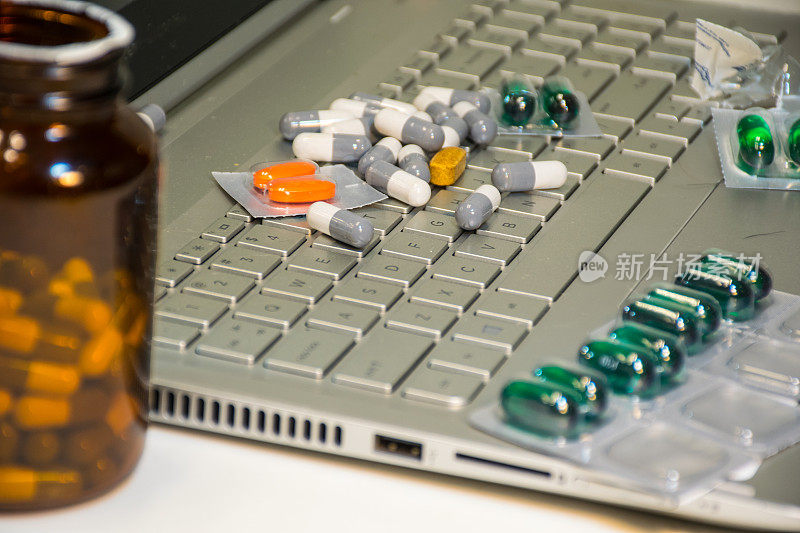 笔记本电脑键盘上的药丸和开药瓶