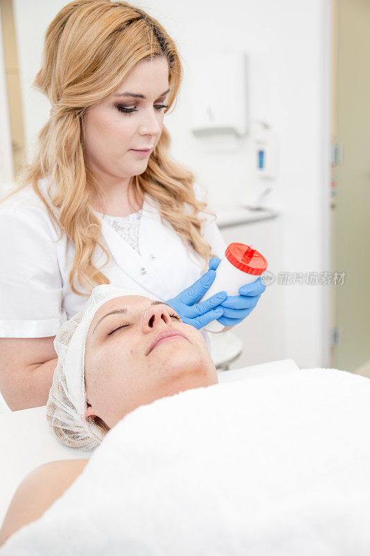 在微晶磨皮治疗后，皮肤科医生在病人脸上涂凡士林