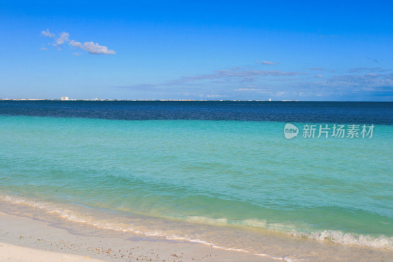 加勒比海与小波浪打破海滩，蓝色和蓝绿色的水和蓝色的天空，坎昆，墨西哥。
