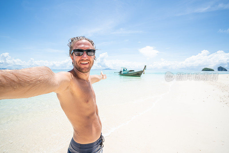 一名年轻人在泰国岛屿清澈的海水中拍摄自拍照。人们旅行奢侈，乐趣和酷的态度概念