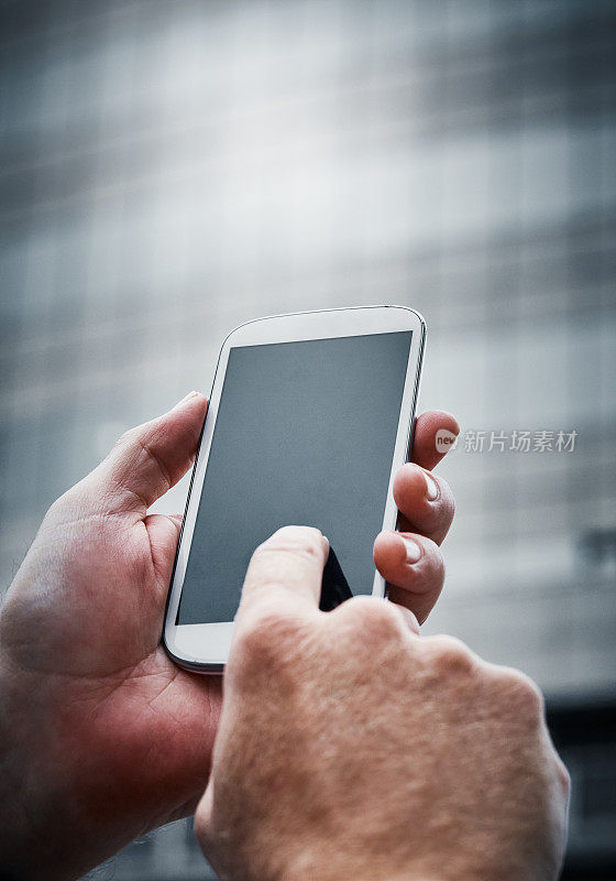 在城市街道上，男性的手敲击着空白的手机屏幕