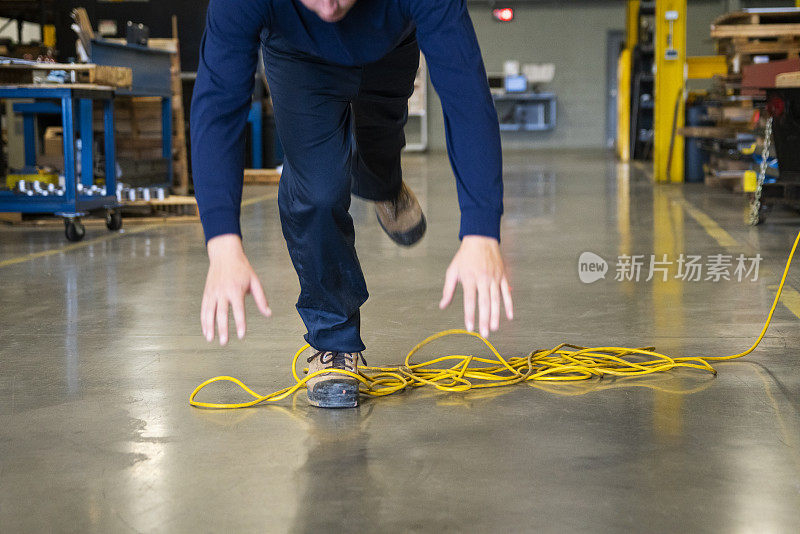 在工业环境中被电线绊倒的工人