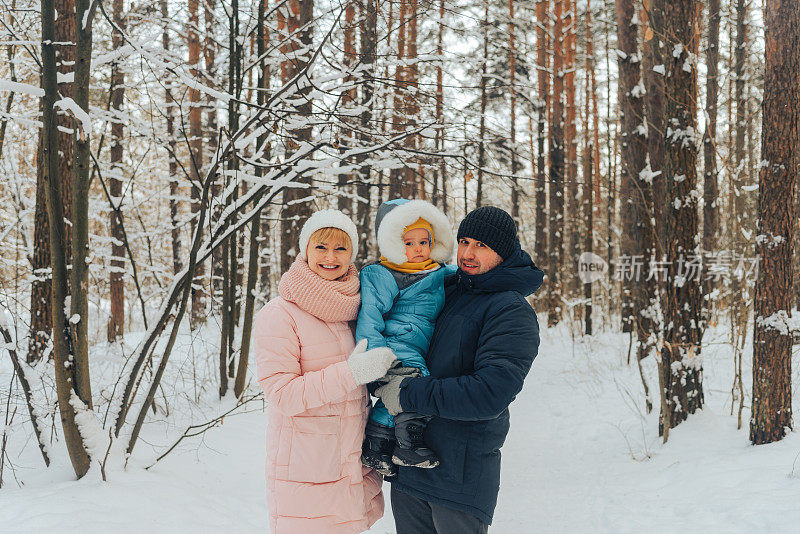 带着孩子的步行家庭。冬天一家人在大自然中散步。冬天一家人在大自然中散步。很多雪。