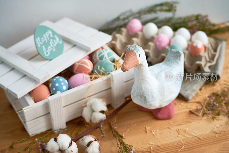 手工制作的鸭子玩具，白色木箱里的复活节彩蛋，用干草铺在脏桌子上的棉花树枝