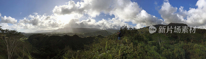 在夏威夷考艾岛，人们徒步攀登山脊，可以看到郁郁葱葱的马卡拉哈山脉