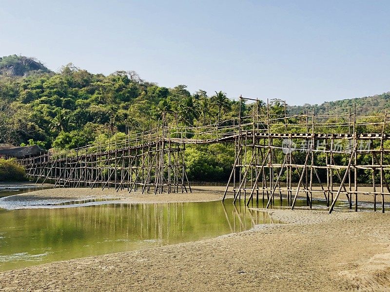 热带海滩岩石池泻湖椰子树，岩石，竹桥和金色的沙像天堂般的海滩度假照片，假日在果阿度假，Palolem海滩，南印度，海岸街道，天然岩石反射水面涟漪