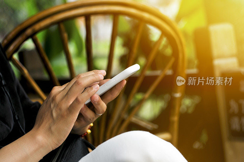 一名中国妇女在茶馆里拿着并触摸着银屏手机