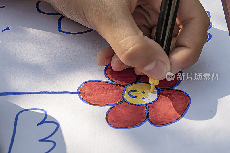 小女孩正在画一幅彩色的花