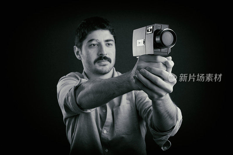 用老式摄影机拍摄的年轻电影摄影师。把相机对准枪