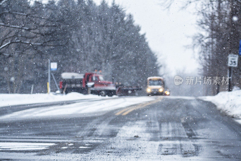 散焦扫雪机进入校车前面的道路