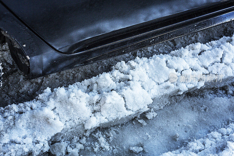 车门下方道路上结冰的雪泥