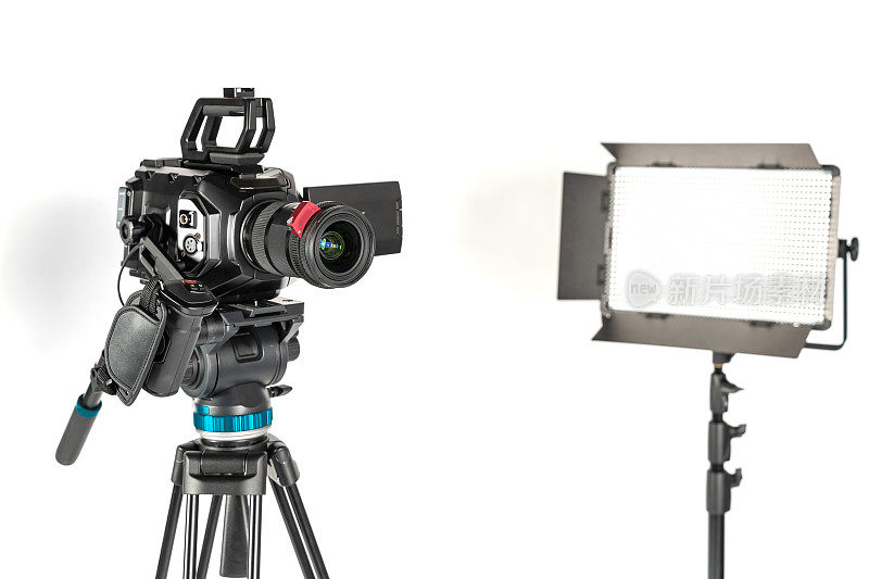 专业影院的摄像机上有摄像机三脚架和专业照明灯具，在工作室的白色背景上剪出