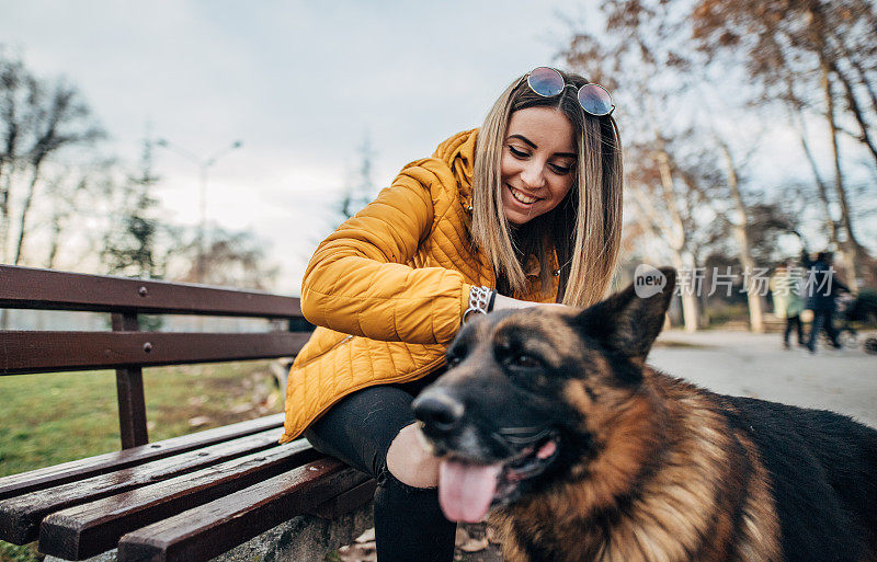 公园里有个年轻女人和一只德国牧羊犬