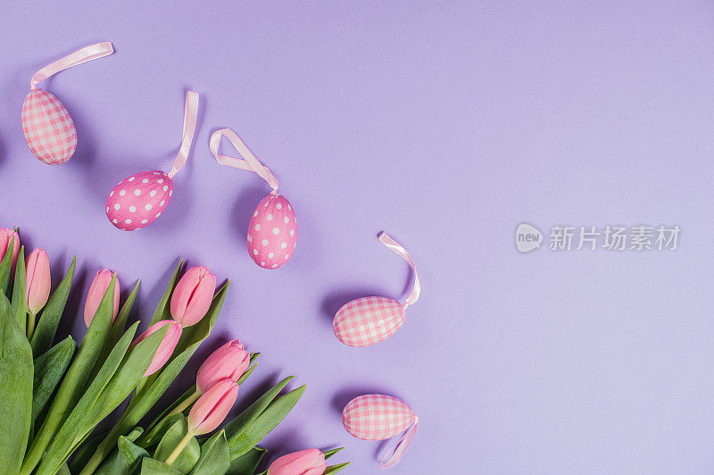 复活节装饰与粉色郁金香和复活节彩蛋在紫色的背景