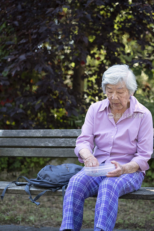 90年代健康活跃的亚洲老年妇女吃蓝莓