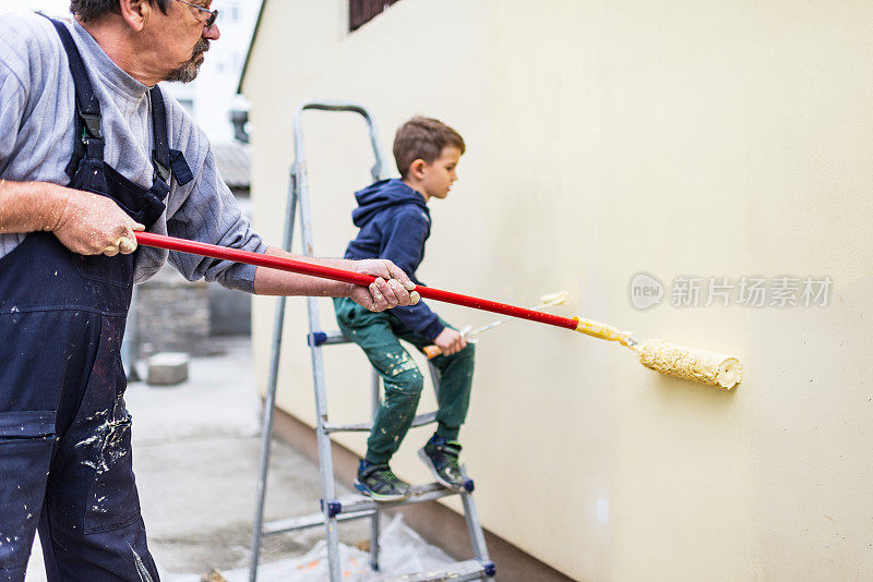 小男孩在帮他爷爷刷墙