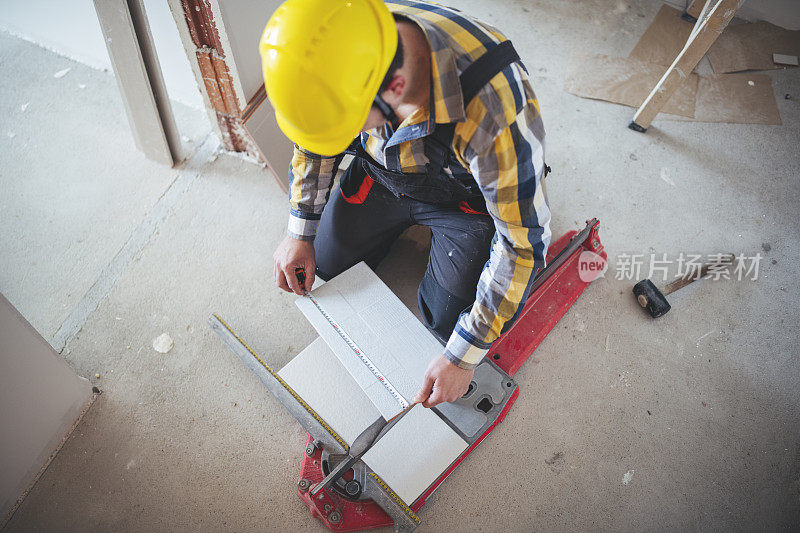 一个建筑工人切割瓷砖的俯视图