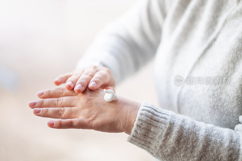 女人用护手霜擦干皮肤