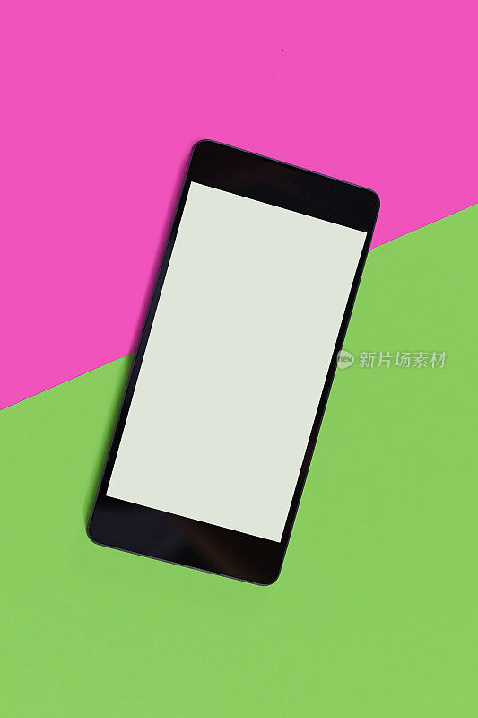 空白智能手机与空白屏幕上的粉红色和绿色背景