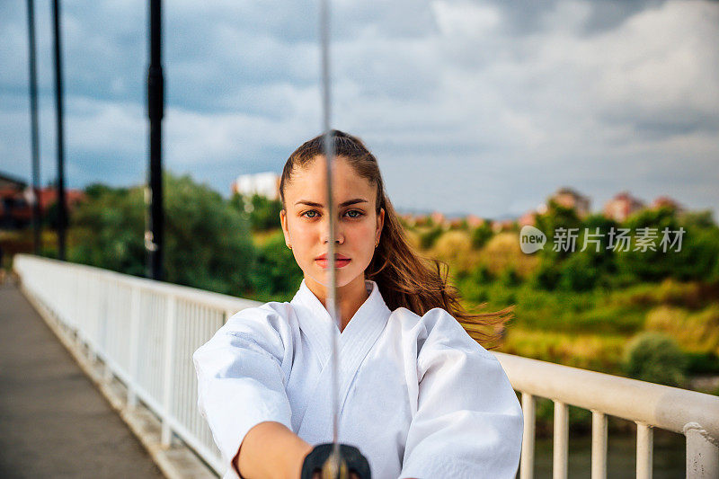 一个年轻女子把武士刀举在面前