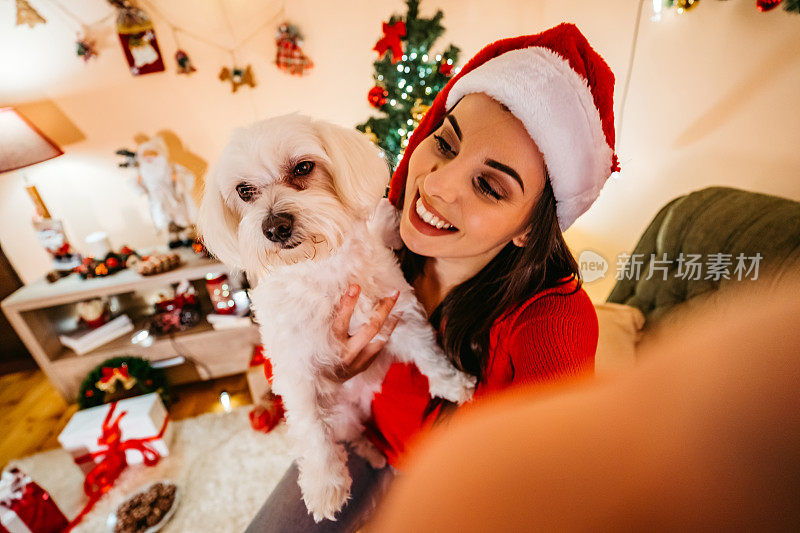 一个女人和一只狗在圣诞自拍