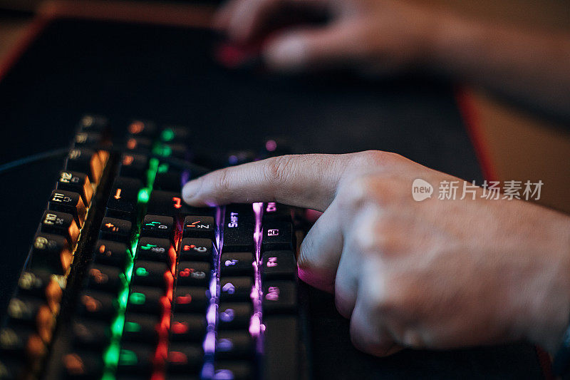男性玩家使用电脑键盘和鼠标玩游戏