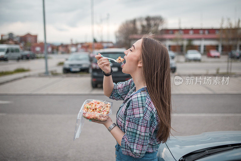 女商人吃着塑料盒子里的沙拉