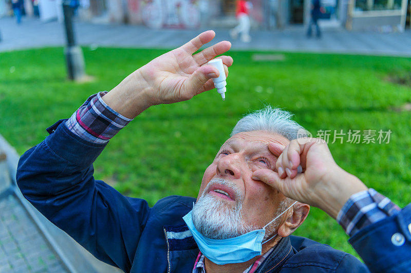 一位老人用眼药水改善视力。