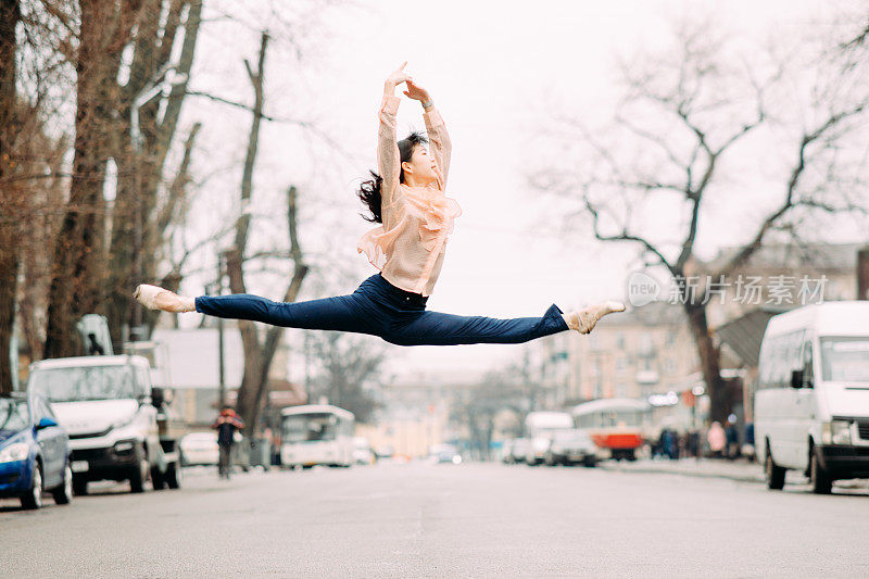 日本芭蕾舞演员在城市街道上表演分裂和跳跃。