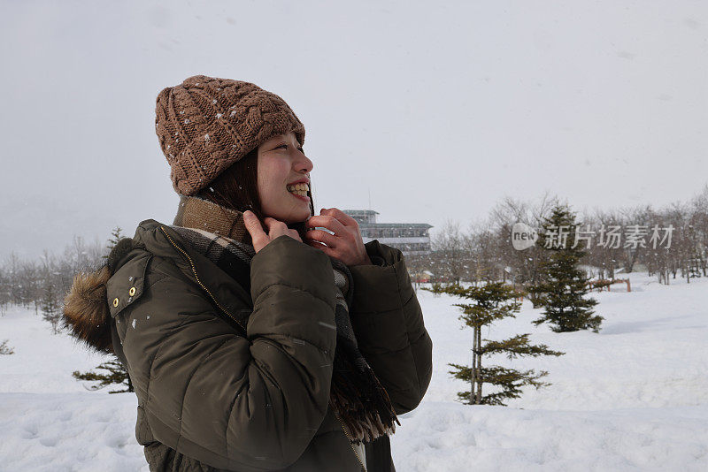 美丽的年轻女子在白雪覆盖的公园放松