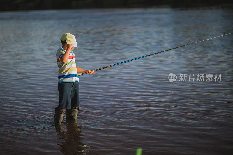 一个男孩在河边钓鱼