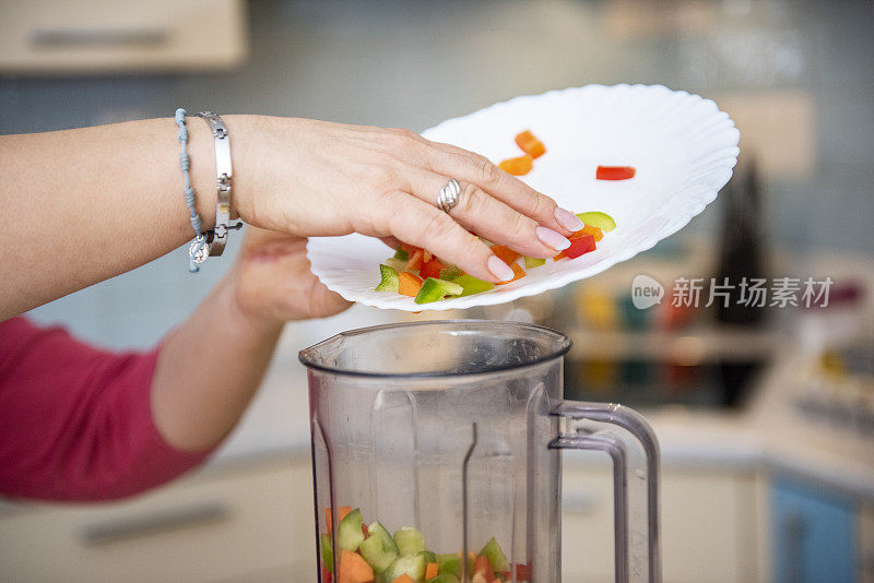 女人准备生物水果和蔬菜奶昔