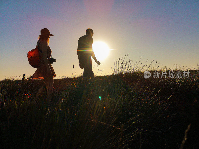 一对年轻的游客徒步旅行在开普敦的桌山山顶在日落前的侧面视图