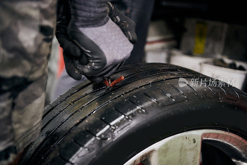 硫化剂在室内汽车修理店的旧轮胎被刺破后，在向洞内注射天然粗橡胶之前，通过插入模具来固定洞