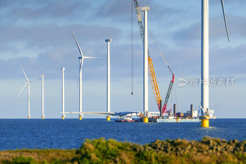 建设海上风电场-荷兰海上风力涡轮机(markmeer)。吊船正准备吊起风力涡轮机的转子。晴朗的天气和大气的心情。