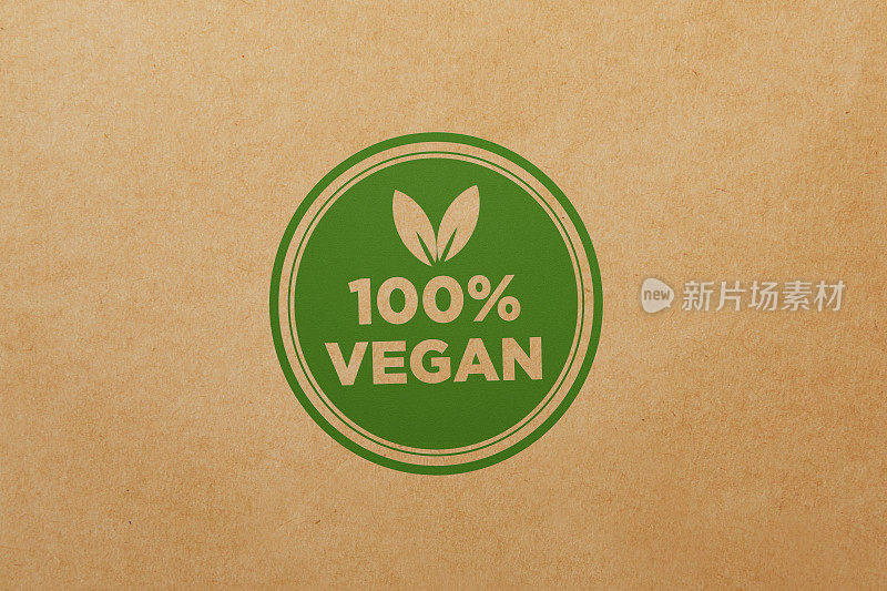 纯素食品概念-绿色100%纯素邮票坐在棕色的纸背景