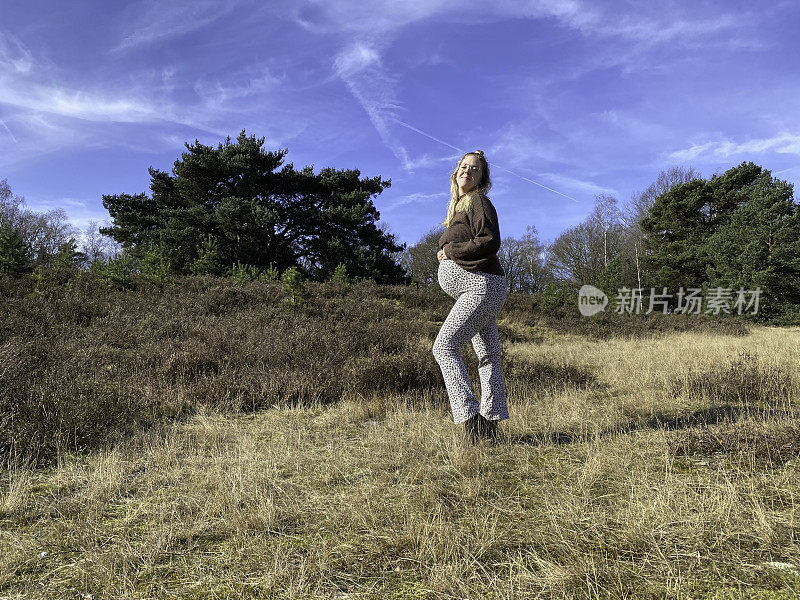 一对双胞胎怀孕的年轻女子走在荒野