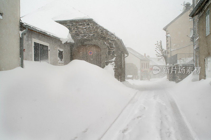 雪地上村庄街道上的轮胎痕迹