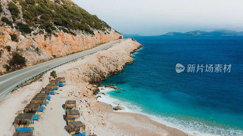 女性在土耳其公路旁风景优美的绿松石海滩上放松的鸟瞰图