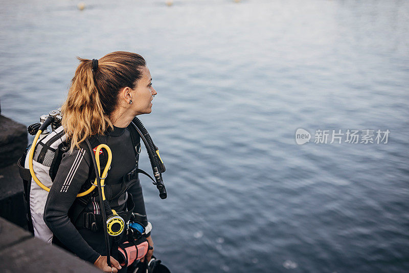 年轻的女潜水员在海里潜水和探索海底