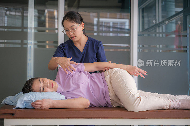 与女医生或物理治疗师进行脊椎按摩背部，手臂和肩膀调整的亚洲女性患者的医疗访问