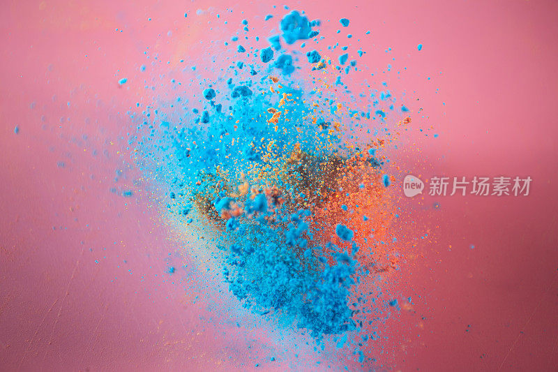 不同颜色的粉末在高速拍摄的粉色背景上爆炸