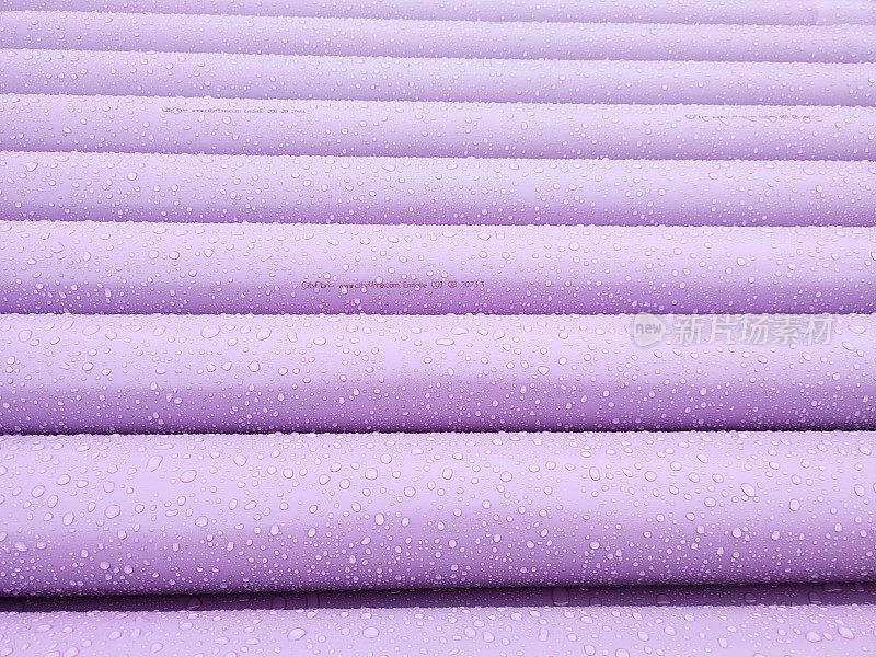 英国苏格兰格拉斯哥的紫色塑料管在雨下堆叠