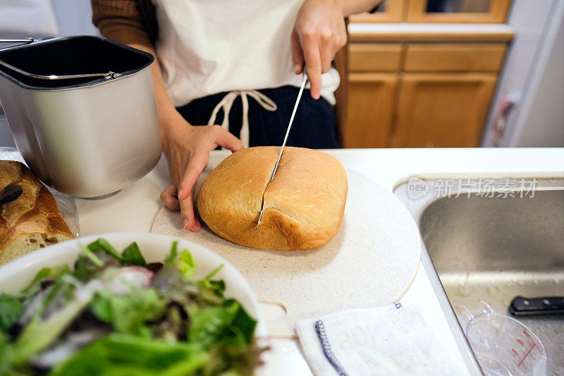 女人在厨房切面包的特写镜头