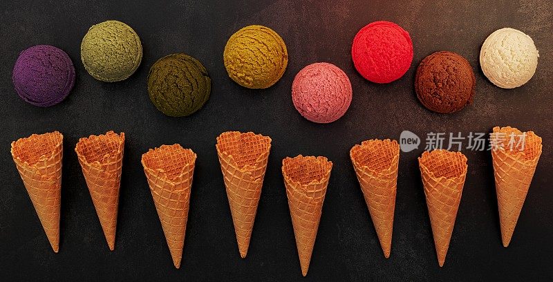 各种口味的冰淇淋蓝莓，开心果，杏仁，橘子，绿茶和巧克力设置在黑色的石头背景。夏日和甜蜜的菜单概念。