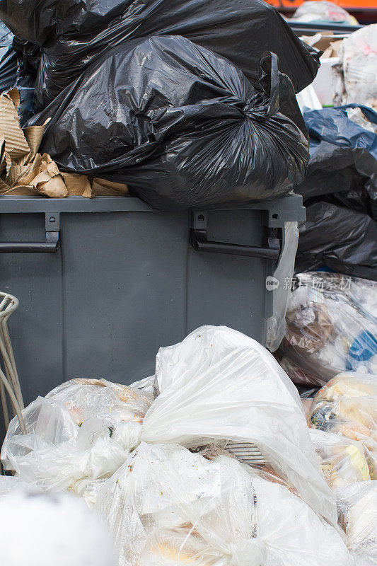 塑料垃圾袋装着食品和垃圾，溢出容器