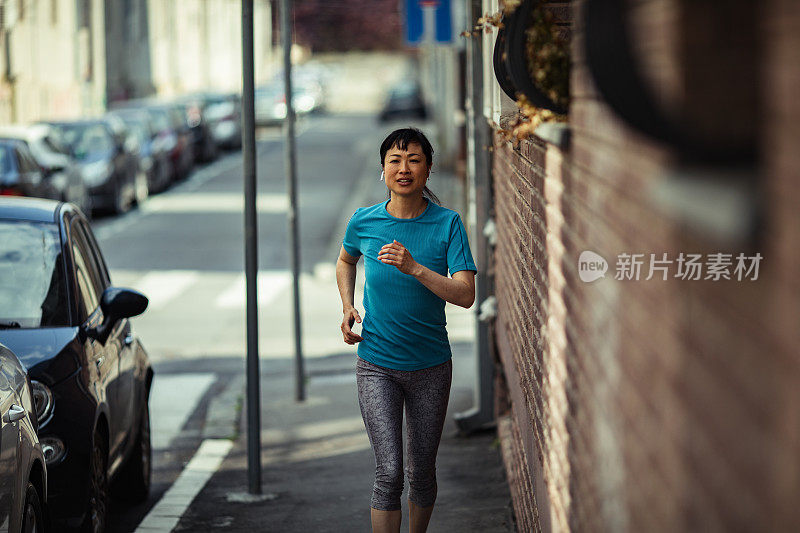 年轻的日本女子在城市街道上慢跑