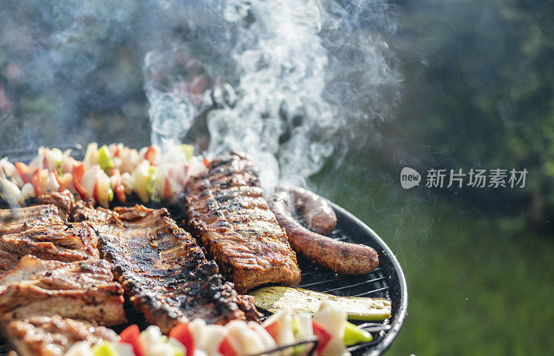 烤肉的特写，牛排和蔬菜在木炭烤架上。